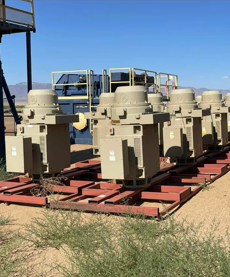 A row of transformers resting on timber cribbing in a yard